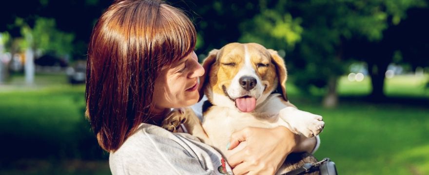 Lady holding beagle puppy.